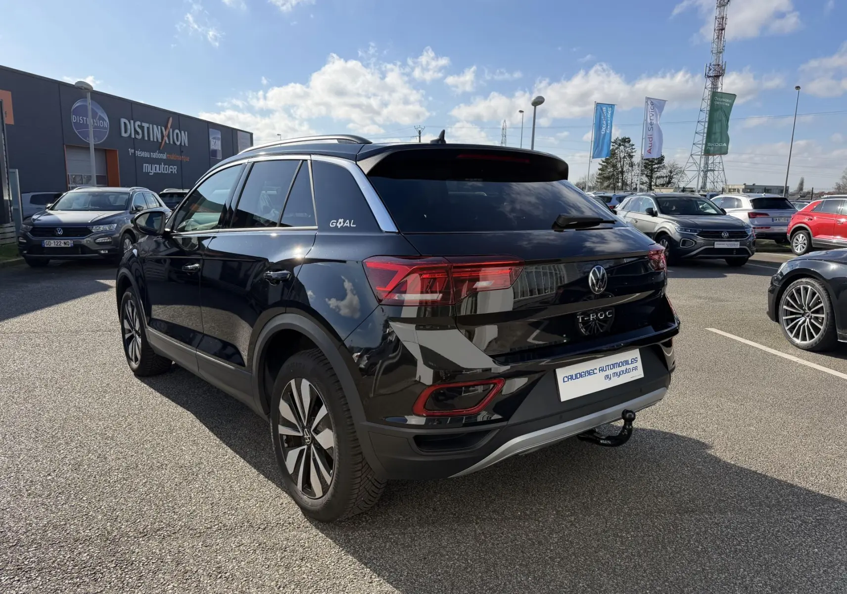 Vue 3/4 arrière droite d'un Volkswagen T-Roc noir avec attelage amovible et vitres arrière surteintées.