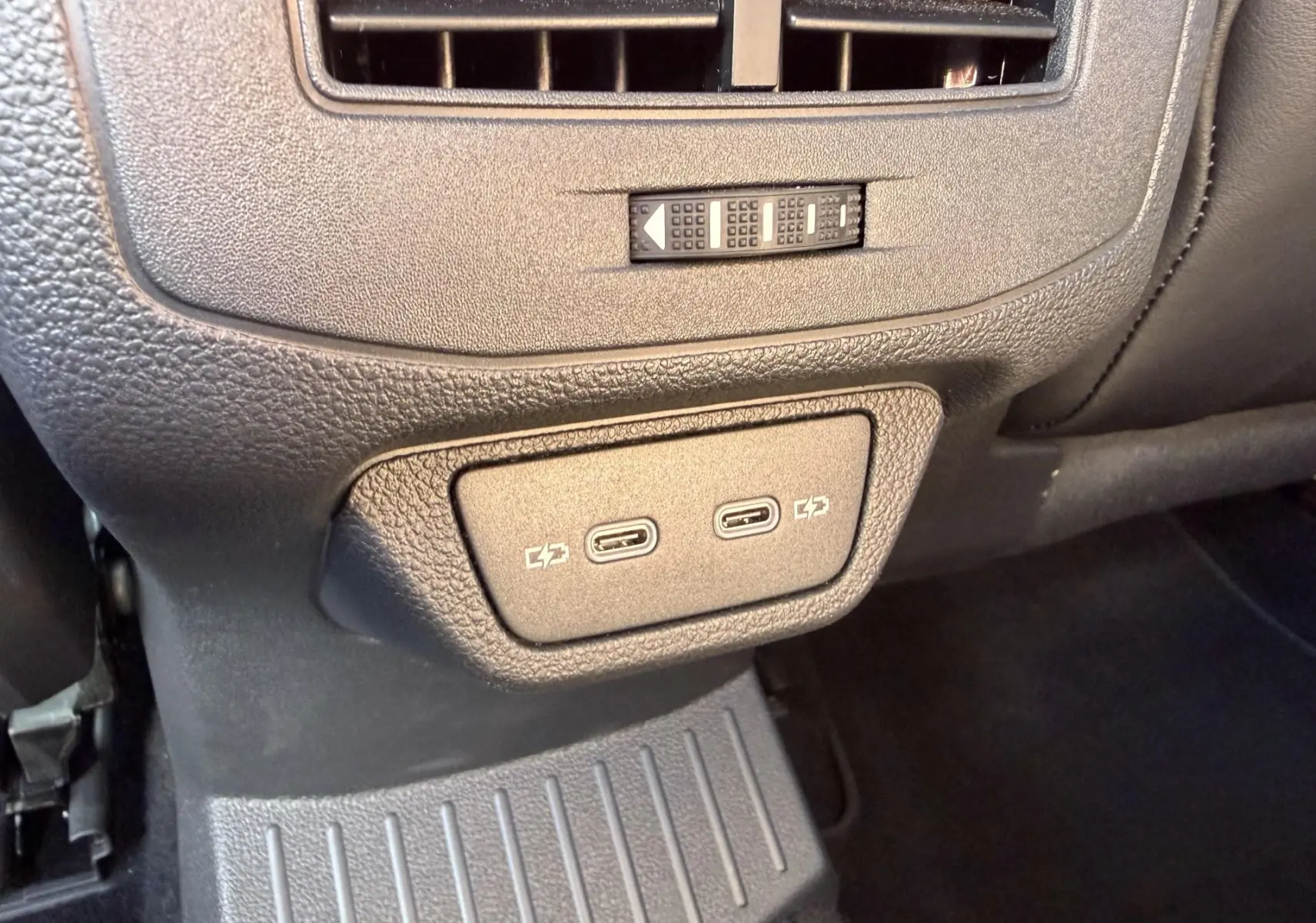 Vue rapprochée des ports USB-C doubles pour recharge situés à l'arrière de la console centrale du Volkswagen T-Roc noir.