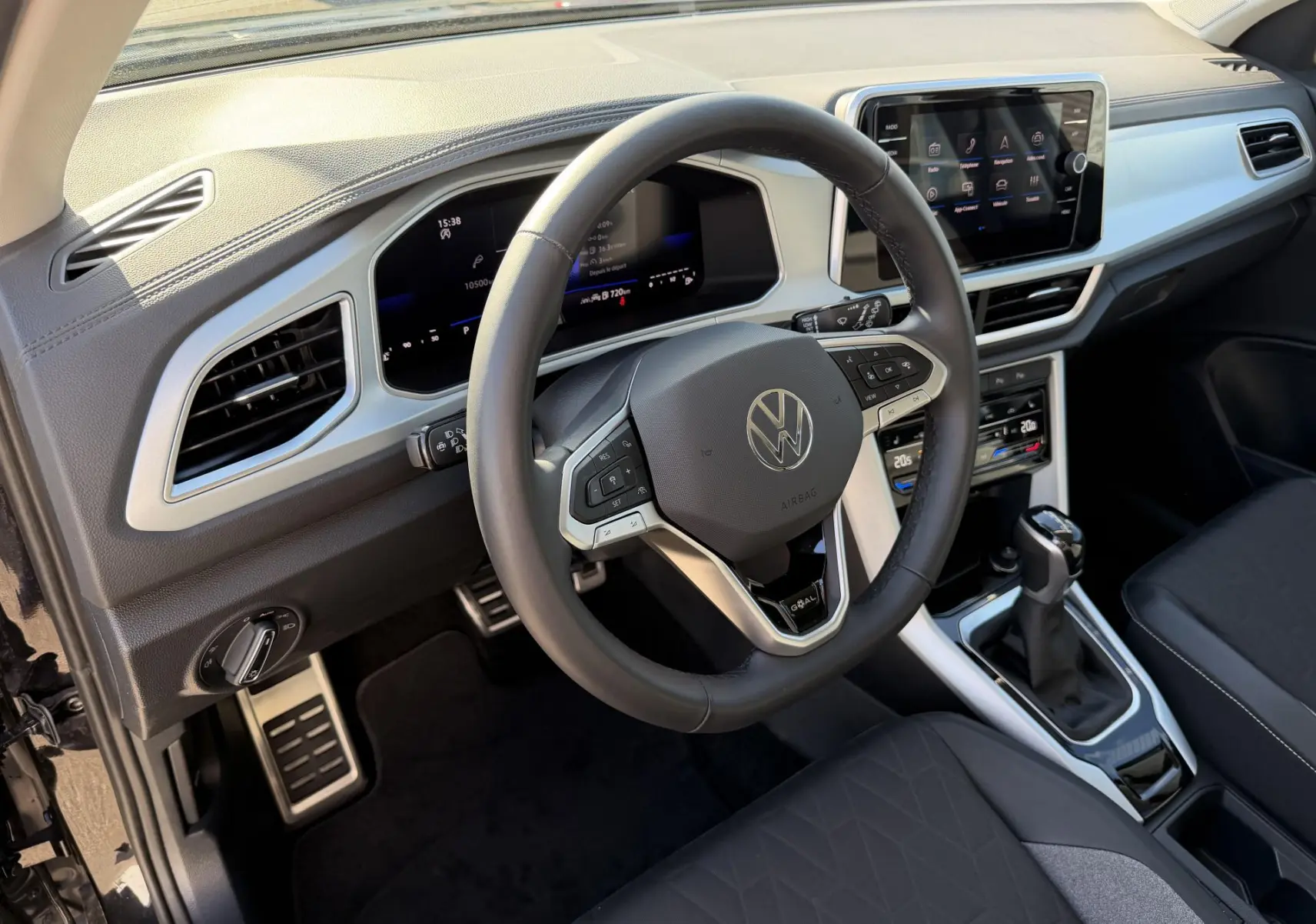 Vue intérieure côté conducteur du Volkswagen T-Roc noir 2025, volant cuir multifonctions et tableau de bord digital.