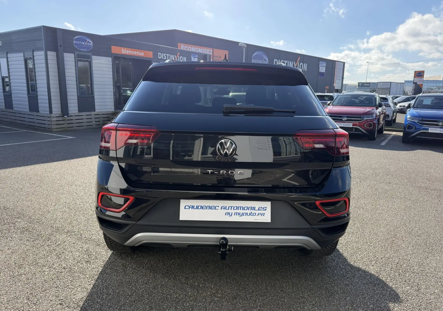 Vue arrière d'un Volkswagen T-Roc noir 2025 avec attelage amovible et feux arrière LED distinctifs.