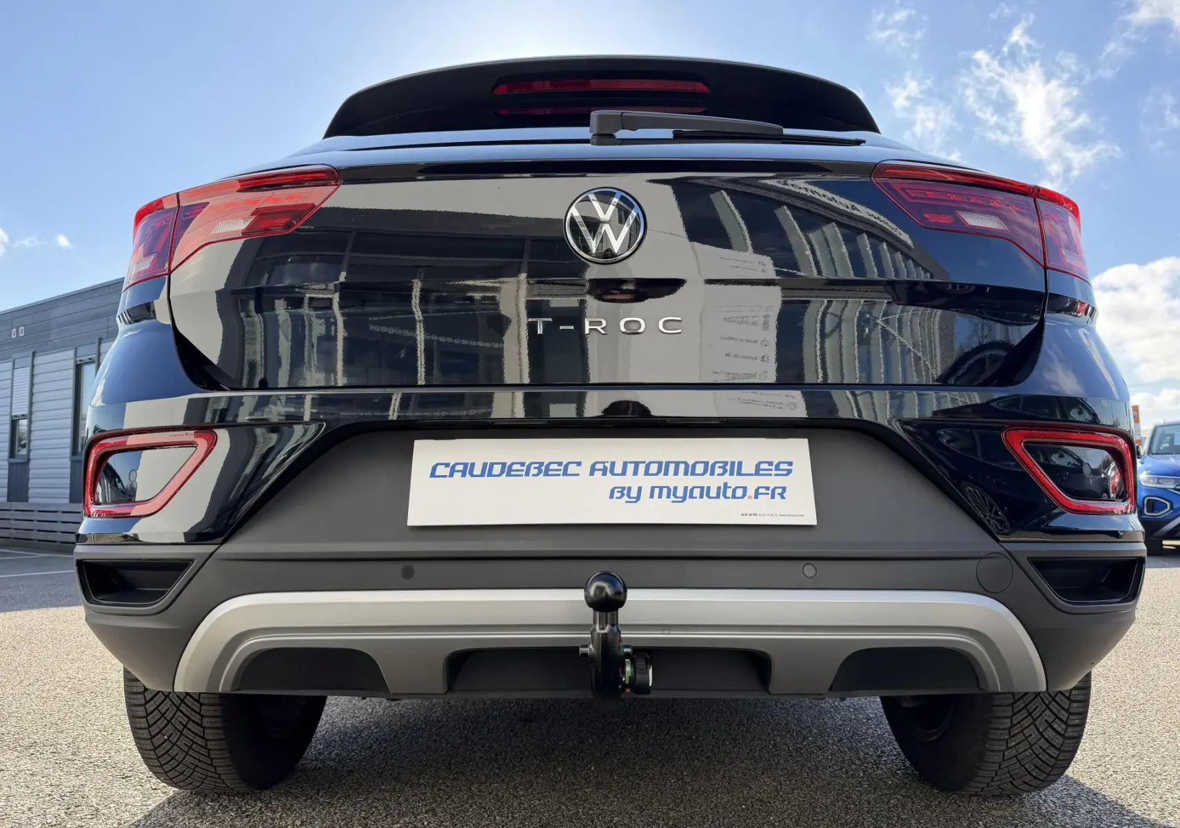 Vue arrière d'un Volkswagen T-Roc noir 2025 avec attelage amovible et feux LED distinctifs.