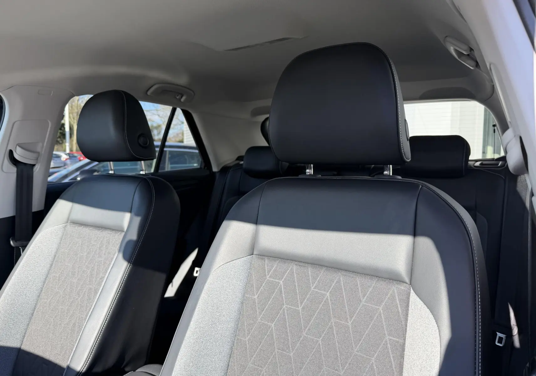Vue intérieure des sièges avant en cuir noir et tissu gris avec motifs géométriques du Volkswagen T-Roc 2025.