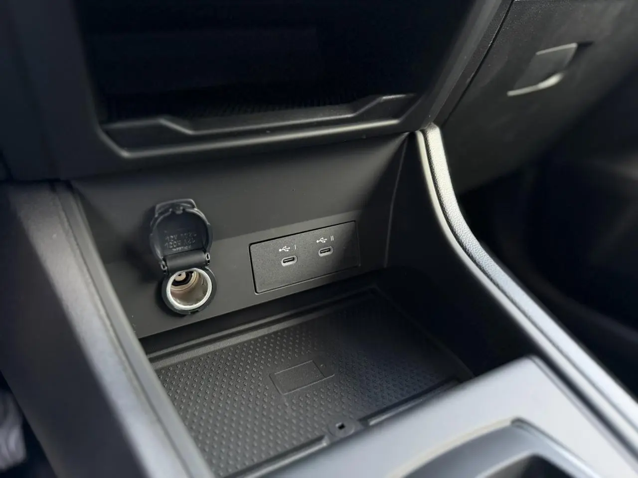 Vue rapprochée de la console centrale noire du Renault Captur 2026, avec prises USB-C et prise 12V ouvertes.