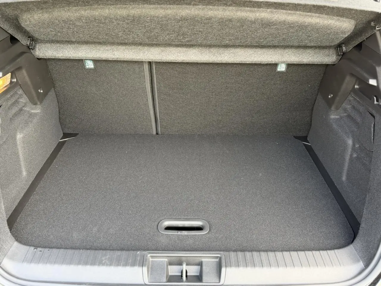 Coffre ouvert du Renault Captur noir étoile, vue intérieure montrant le plancher de coffre mobile et espace de rangement.