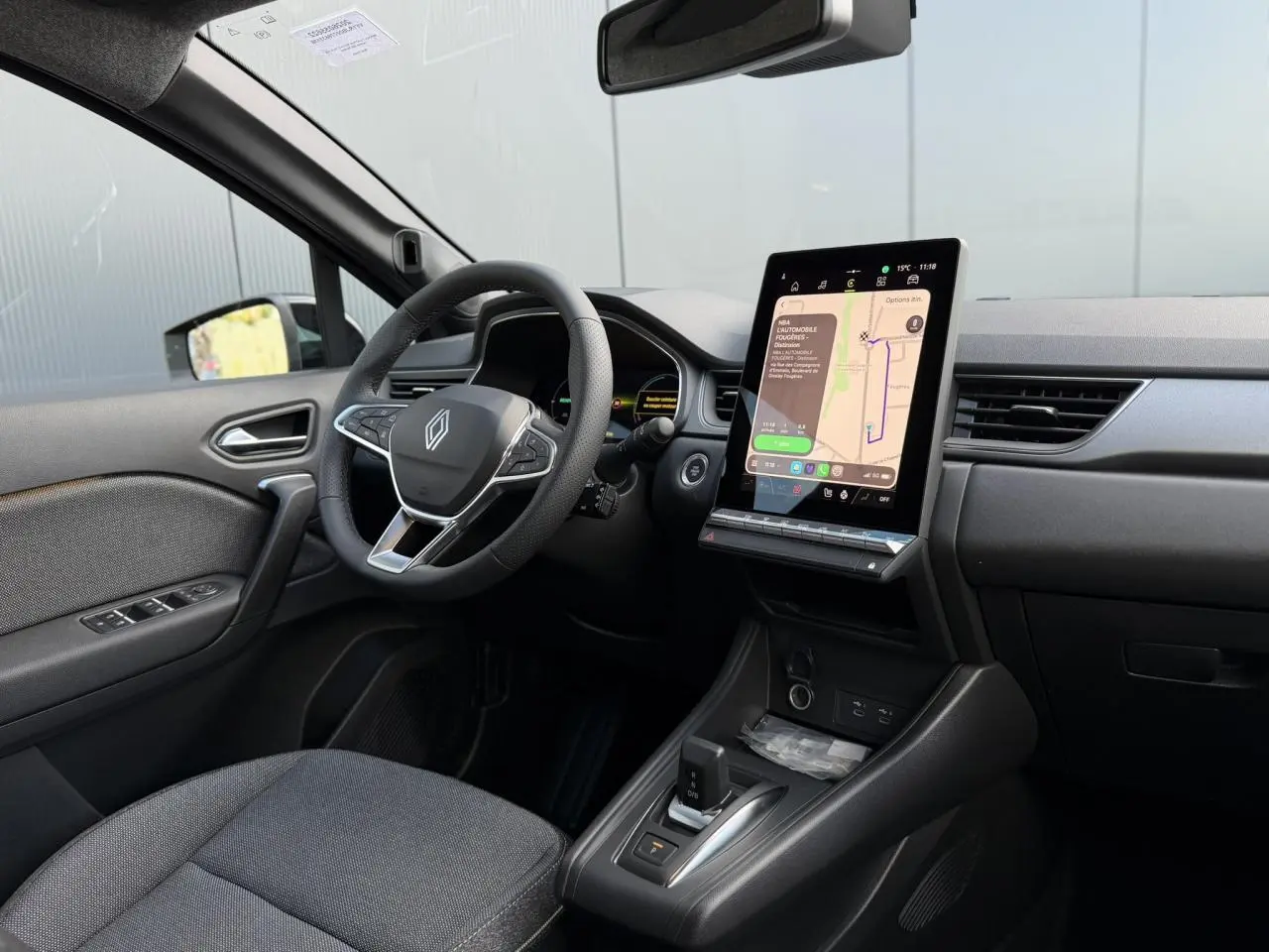 Vue intérieure côté conducteur du Renault Captur 2026 noir étoile, avec écran tactile vertical et volant multifonction.