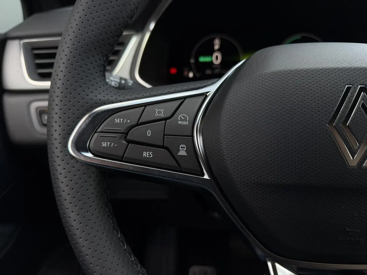 Gros plan sur le volant noir perforé du Renault Captur 2026, avec commandes intégrées côté gauche.