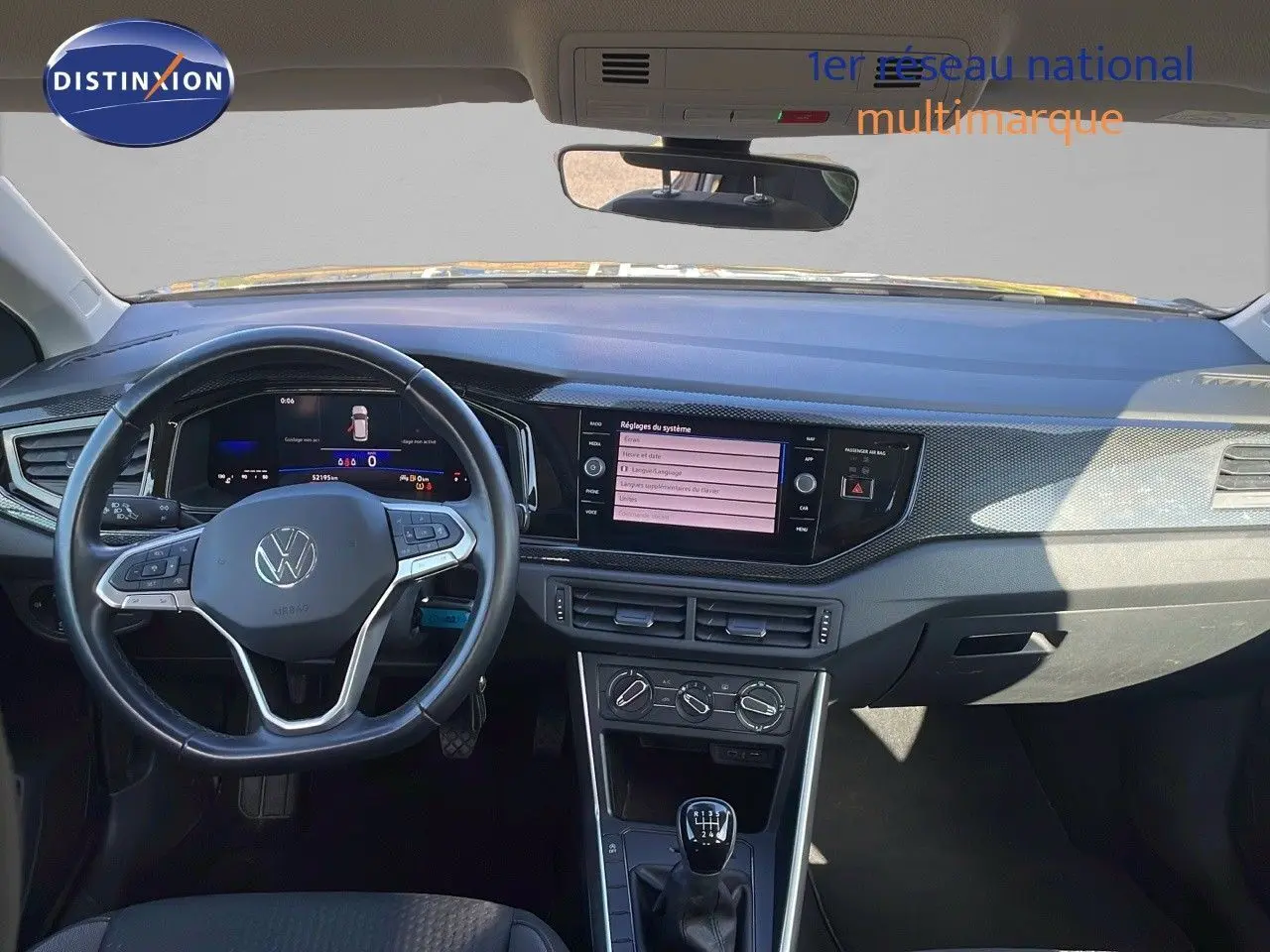 Vue intérieure frontale du tableau de bord et volant noir du Volkswagen Taigo gris cendre 2022 avec boîte manuelle.