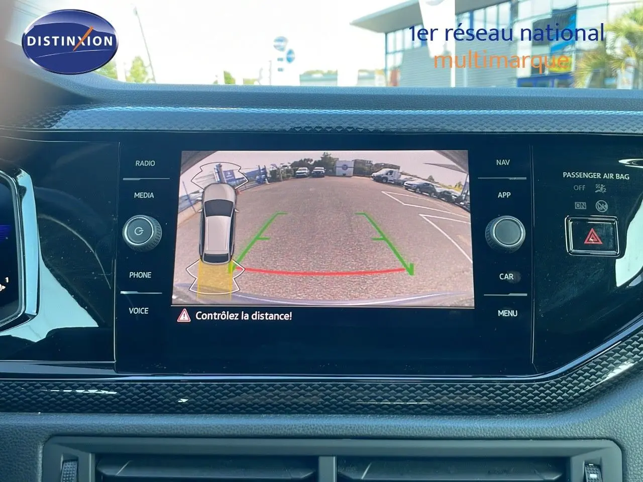 Vue intérieure du tableau de bord du Volkswagen Taigo gris cendre 2022 avec écran de caméra de recul affichant l'arrière du véhicule.