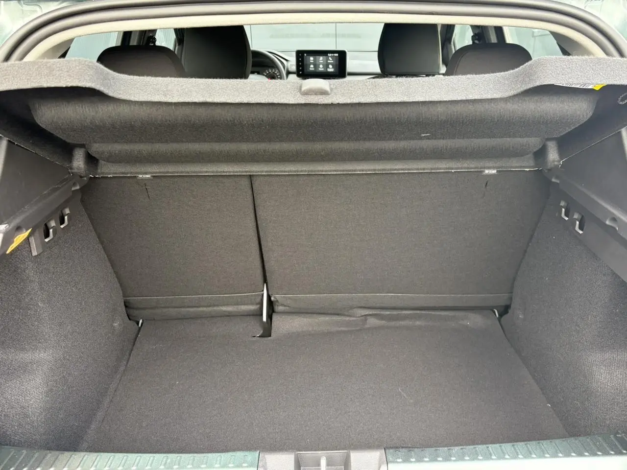 Vue intérieure du coffre spacieux de la Dacia Sandero Stepway 2025, avec banquette arrière rabattable et habillage gris foncé.