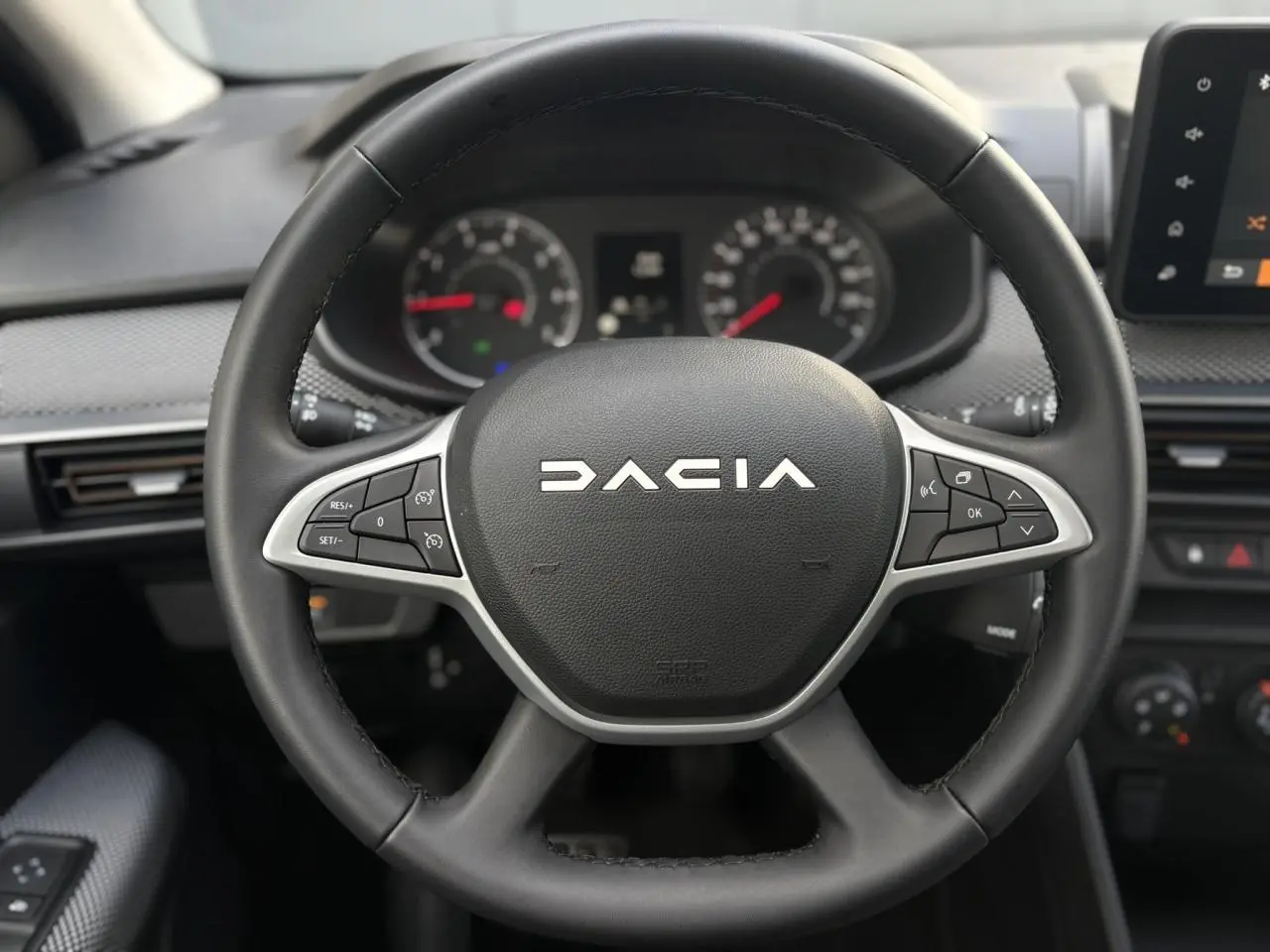 Volant noir de Dacia Sandero Stepway 2025 vu de face, avec commandes intégrées et tableau de bord numérique.