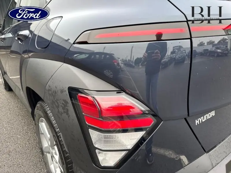 Gros plan sur le feu arrière gauche d'un Hyundai Kona 2023 Denim Blue perlé métallisé, avec reflet sur la carrosserie.