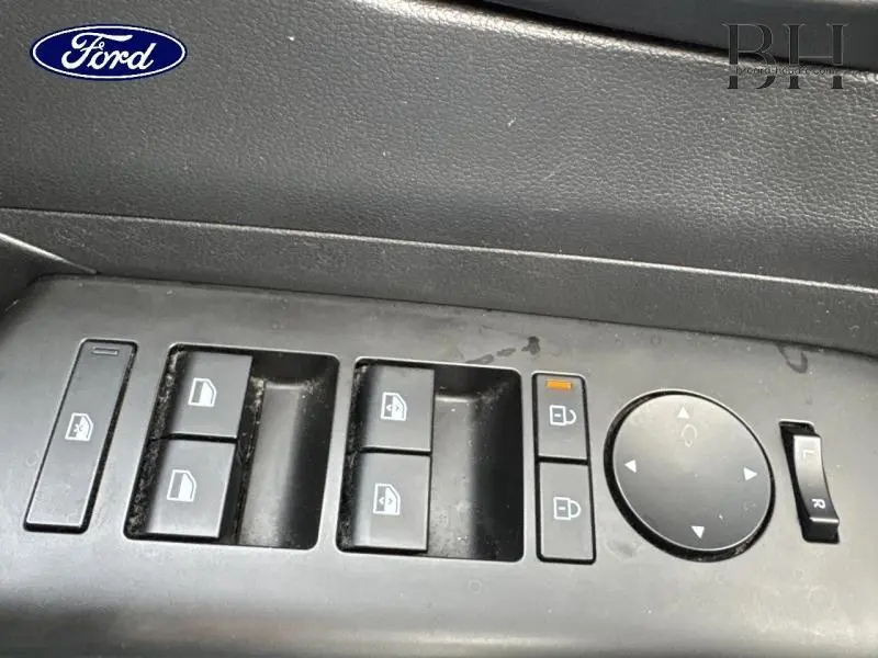 Gros plan sur les commandes de lève-vitres et rétroviseurs côté conducteur d'un Hyundai Kona Denim Blue 2023.