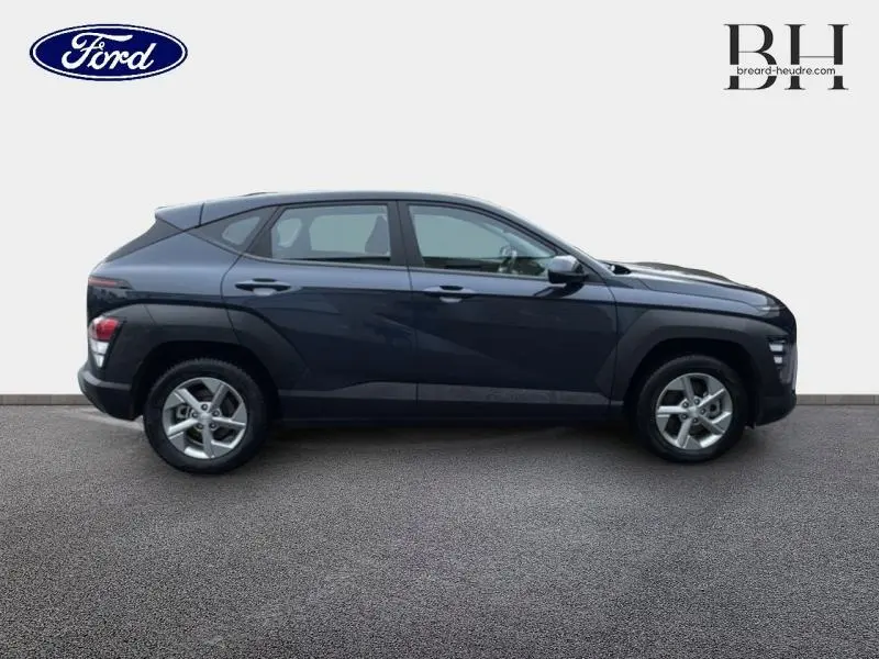 Profil droit d'un Hyundai Kona 2023 en Denim Blue perlé métallisé avec jantes alu et lignes modernes.