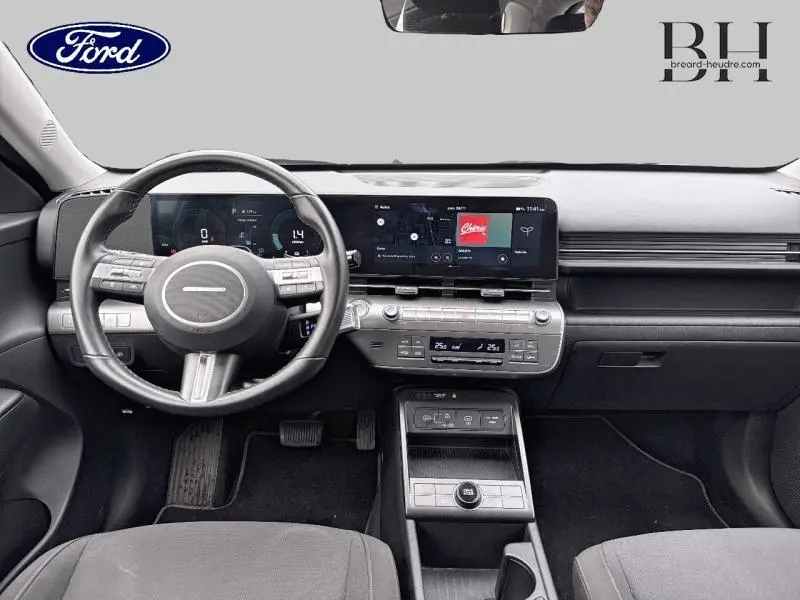 Tableau de bord et volant cuir noir d'une Hyundai Kona 1.6 GDi Hybrid 2023, avec écran tactile large et commandes intégrées.