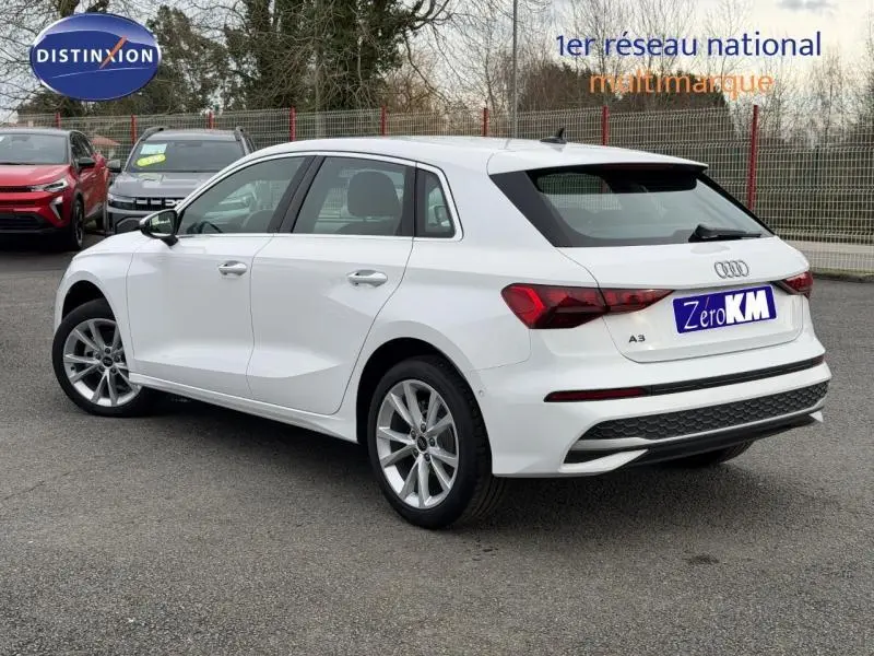 Audi A3 Sportback blanc Arkona vue 3/4 arrière droit, avec jantes alu et becquet arrière noir.