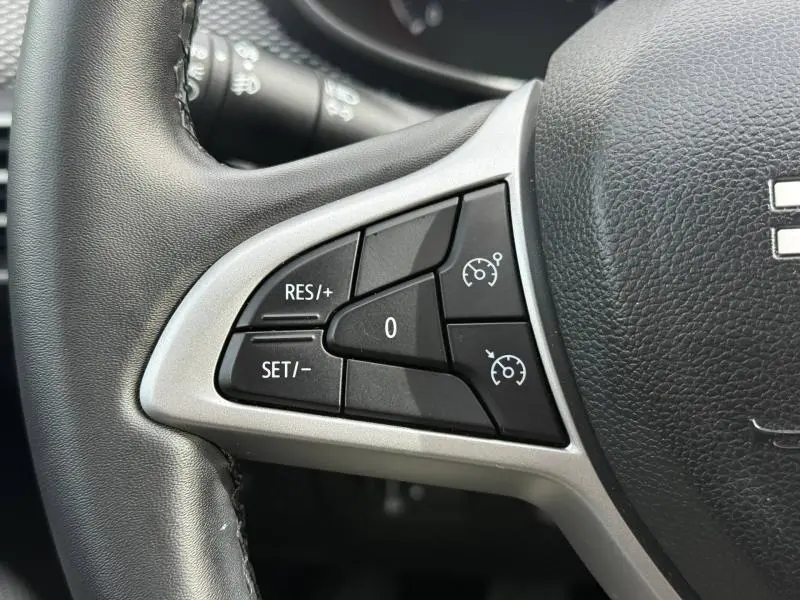 Gros plan sur les commandes de régulateur de vitesse au volant du Dacia Jogger 2025, finition Expression, cuir noir.