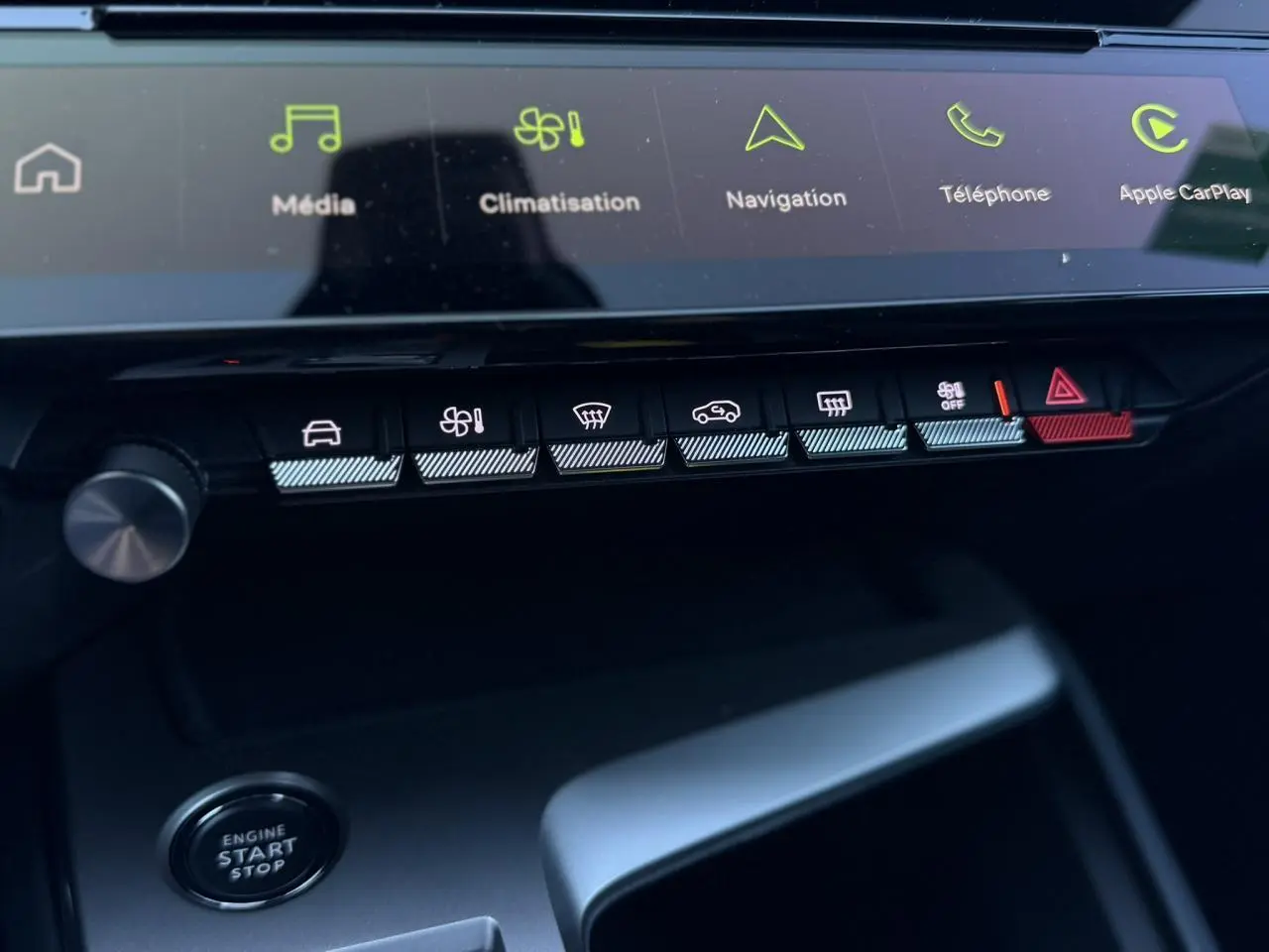 Gros plan sur la console centrale du Peugeot 408 Hybrid blanc, avec écran tactile et boutons de commande éclairés.