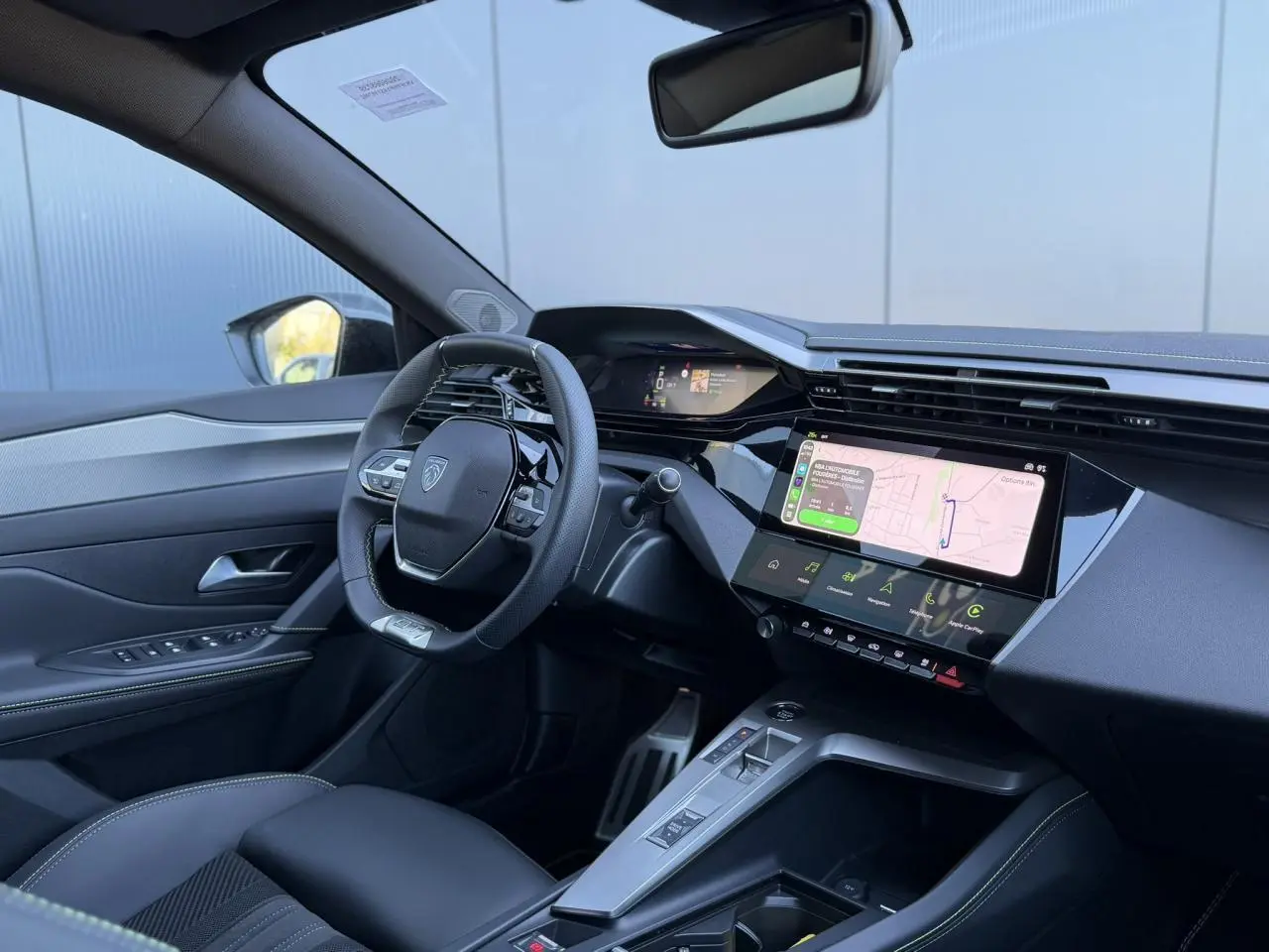 Vue intérieure côté conducteur du Peugeot 408 Hybrid 145 GT 2025, avec tableau de bord numérique et écran tactile central.