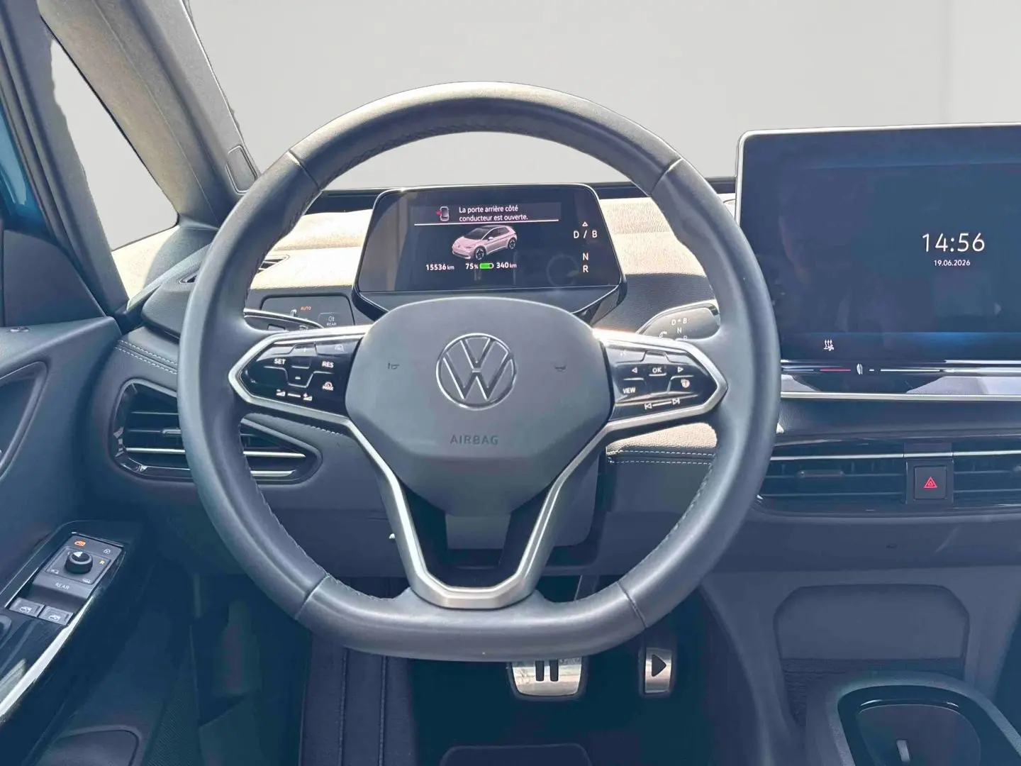 Vue intérieure centrée sur le volant multifonction et l'écran digital du tableau de bord d'une Volkswagen ID.3 bleue.