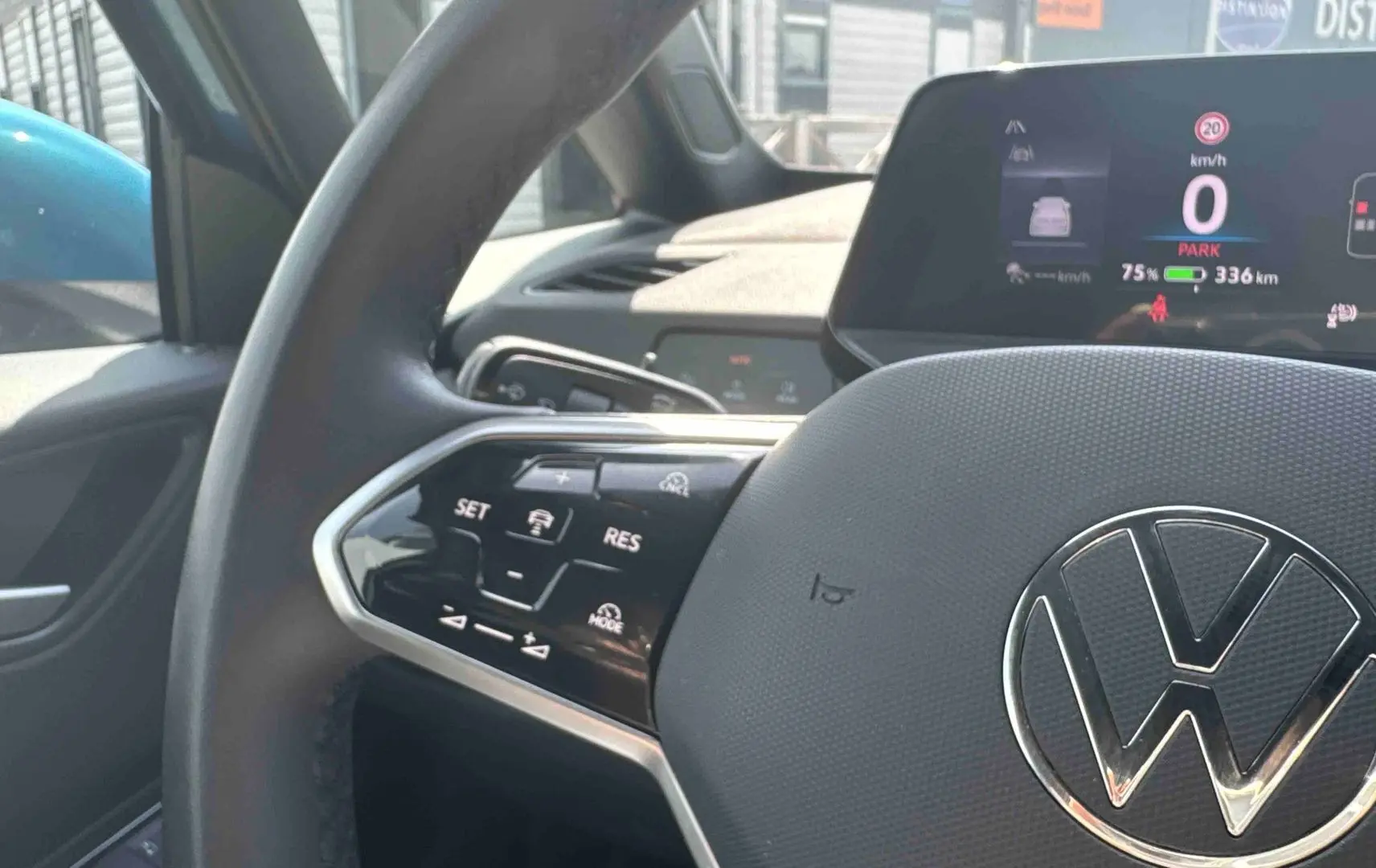 Gros plan sur le volant multifonction noir et l'écran digital du tableau de bord d'une Volkswagen ID.3 électrique.
