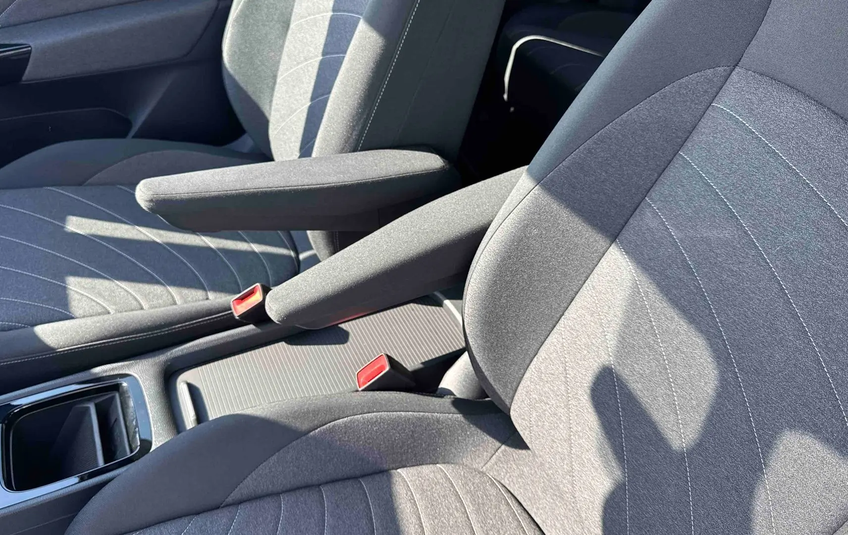 Vue rapprochée des sièges avant gris avec accoudoirs centraux du Volkswagen ID.3 2025.