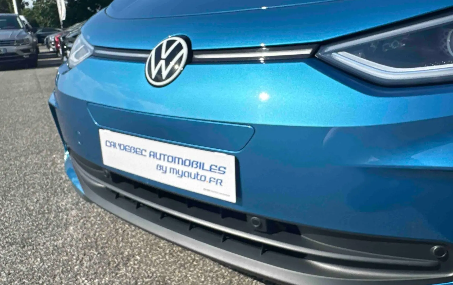 Vue rapprochée 3/4 avant du Volkswagen ID.3 bleu métallisé avec logo VW et calandre épurée noire.