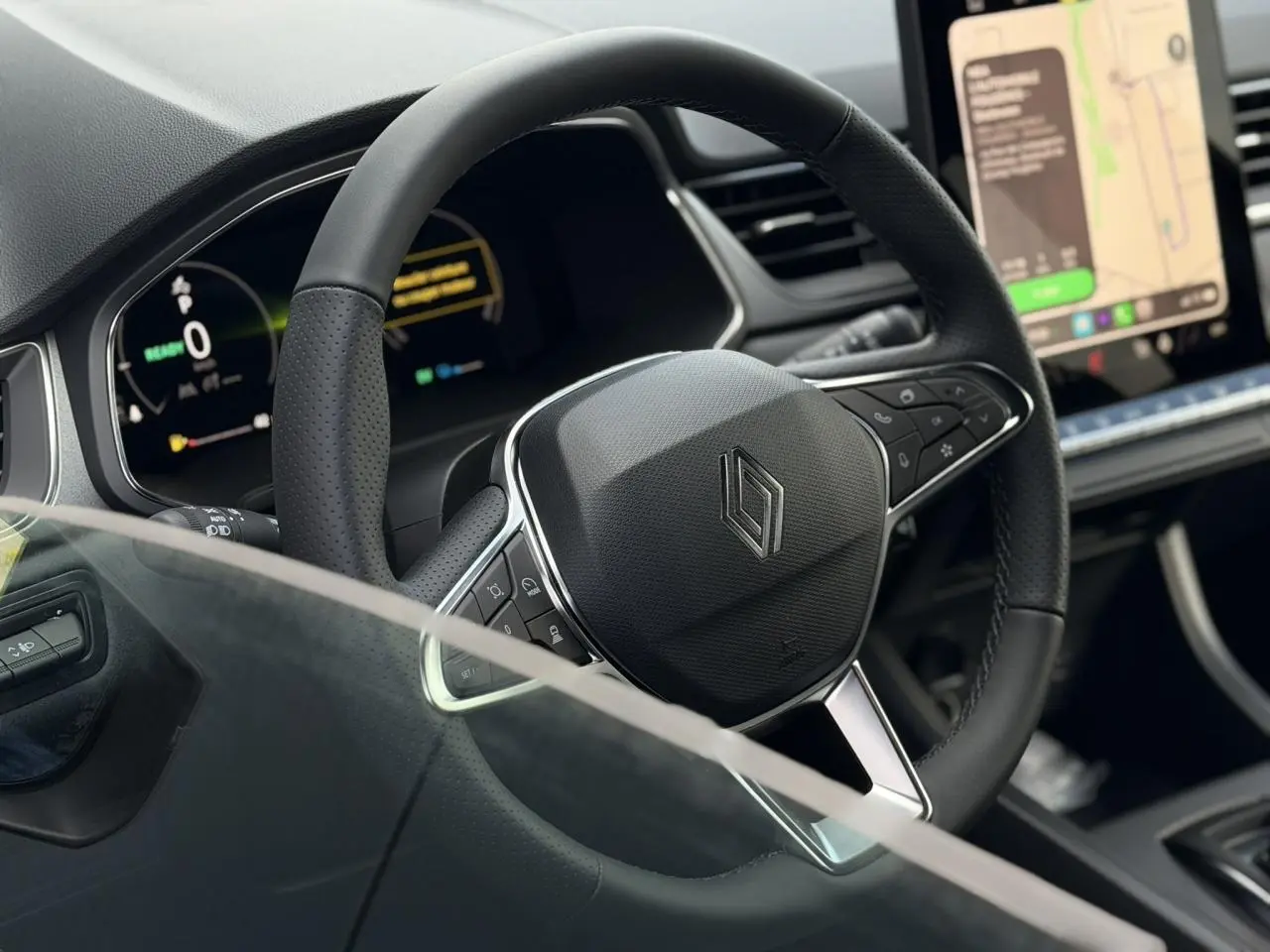 Vue rapprochée du volant noir en textile refined du Renault Captur 2026 avec tableau de bord numérique et écran tactile.
