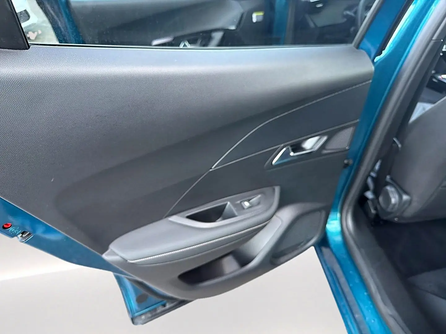 Vue intérieure sur la porte arrière gauche bleu obsession d'un Peugeot 2008 1.2 hybrid 145 allure e-dcs6 2026.