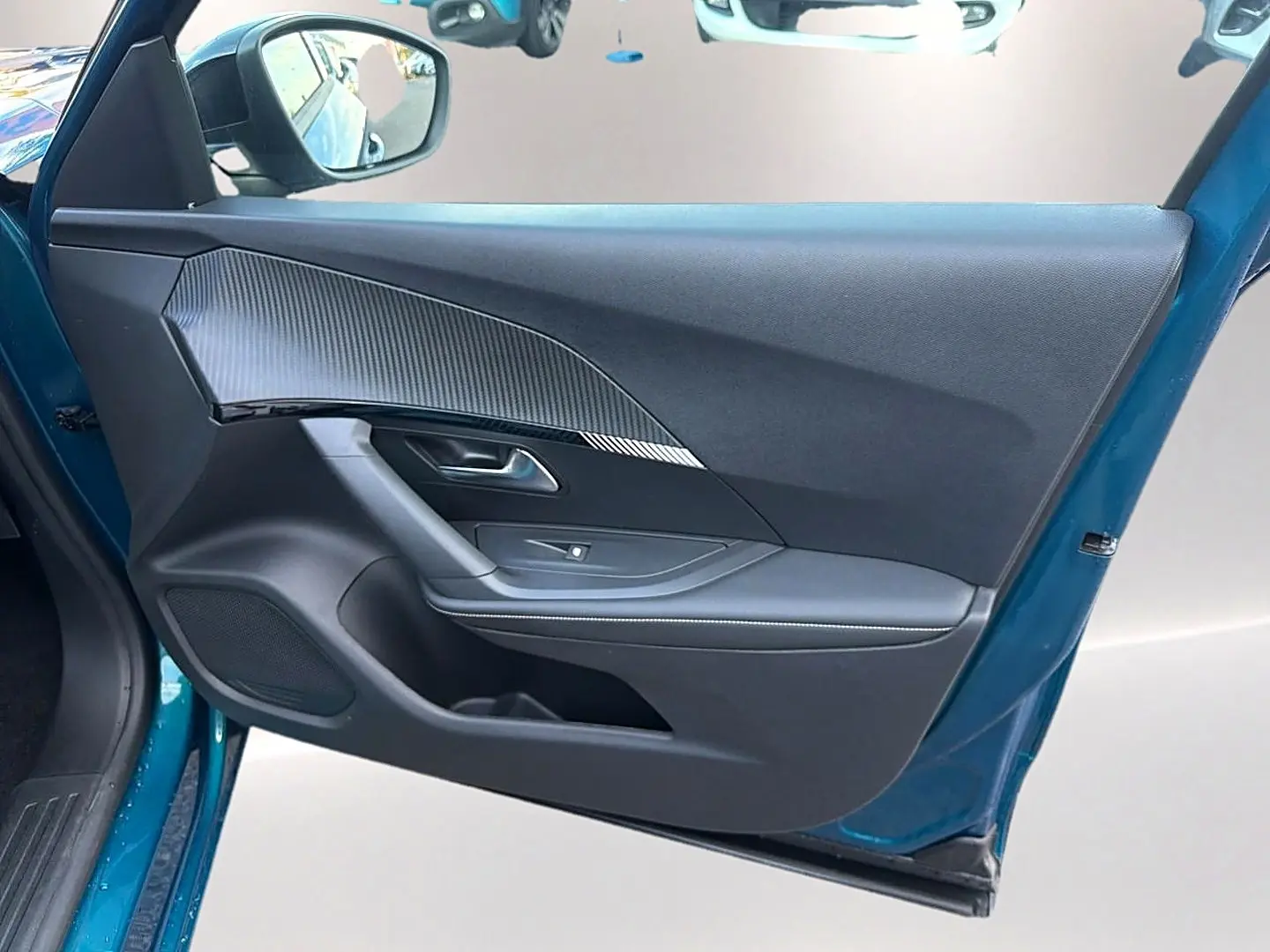 Vue intérieure de la porte avant gauche bleu obsession d'une Peugeot 2008 1.2 hybrid 145 allure e-dcs6 avec habillage noir et insert carbone.