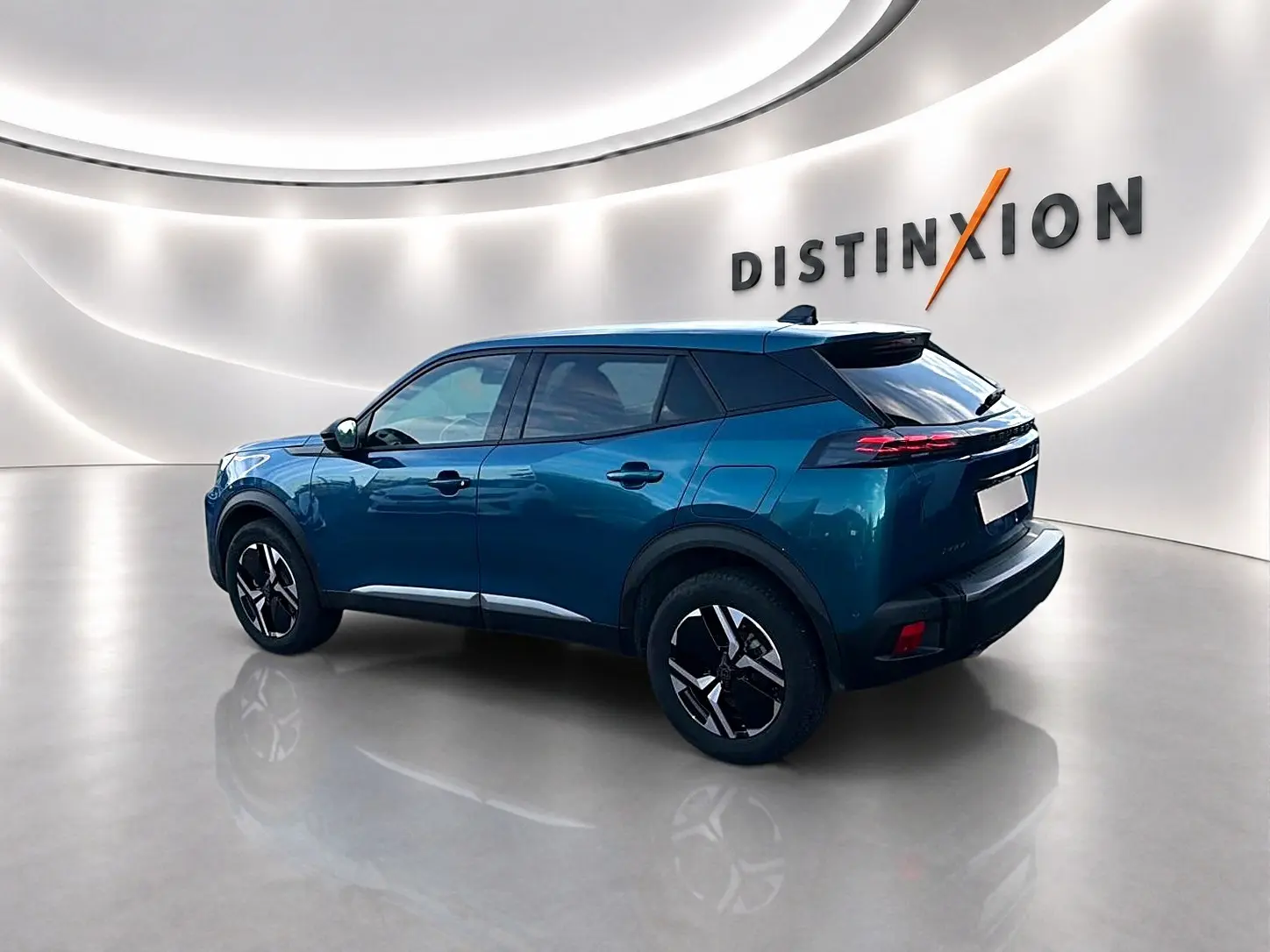 Peugeot 2008 bleu obsession vue 3/4 arrière droit en intérieur avec jantes alu et feux arrière LED distinctifs.