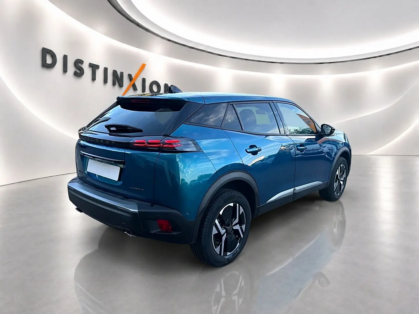 Peugeot 2008 bleu obsession vue 3/4 arrière droit avec jantes alu et feux arrière LED dans showroom lumineux.