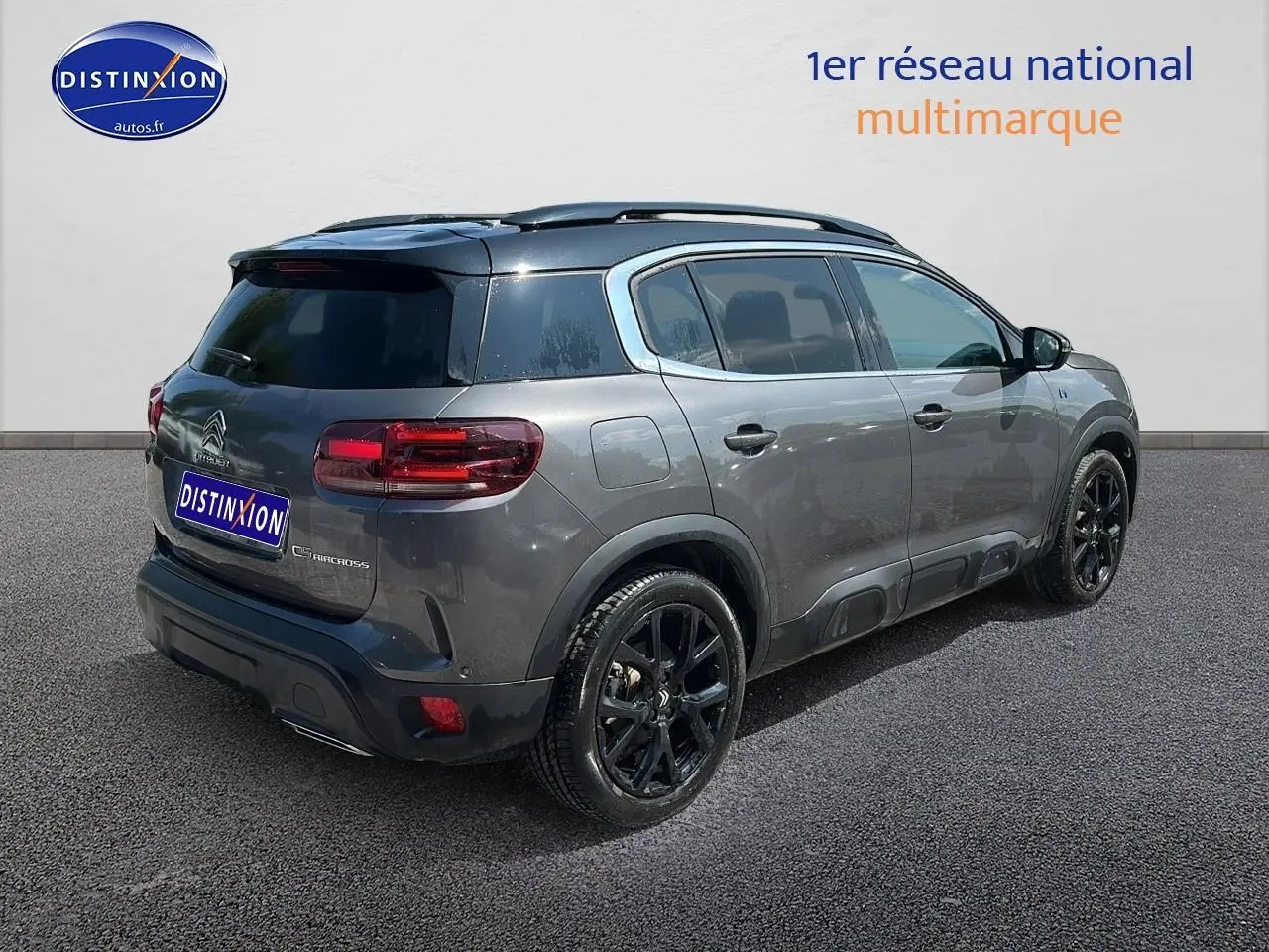 Vue 3/4 arrière droite d'un Citroën C5 Aircross gris platinium avec jantes noires et vitres teintées.