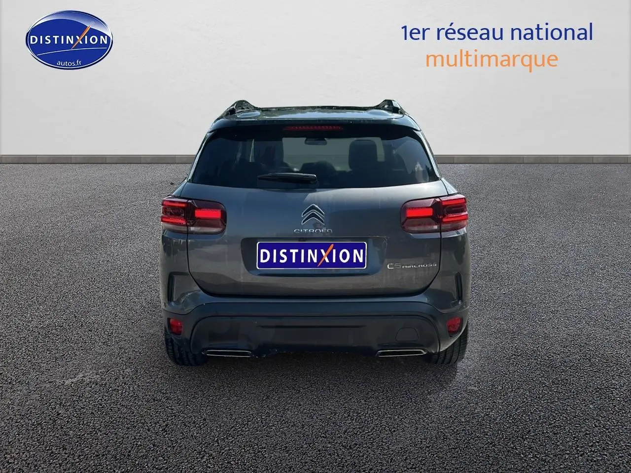 Vue arrière d'un Citroën C5 Aircross gris platinium avec feux LED et barres de toit visibles.