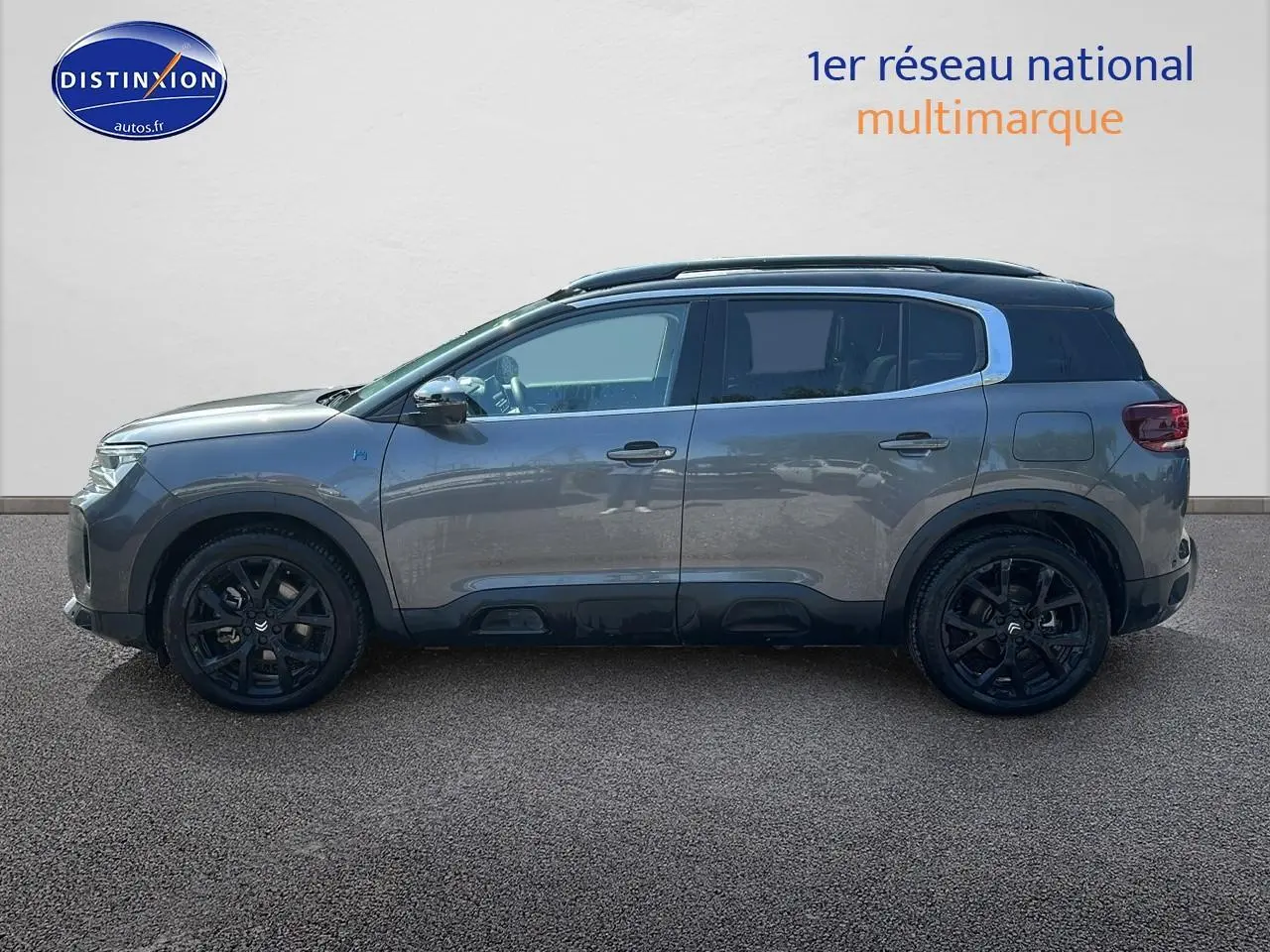 Profil droit du Citroën C5 Aircross gris platinium 2024 avec jantes noires et barres de toit visibles.