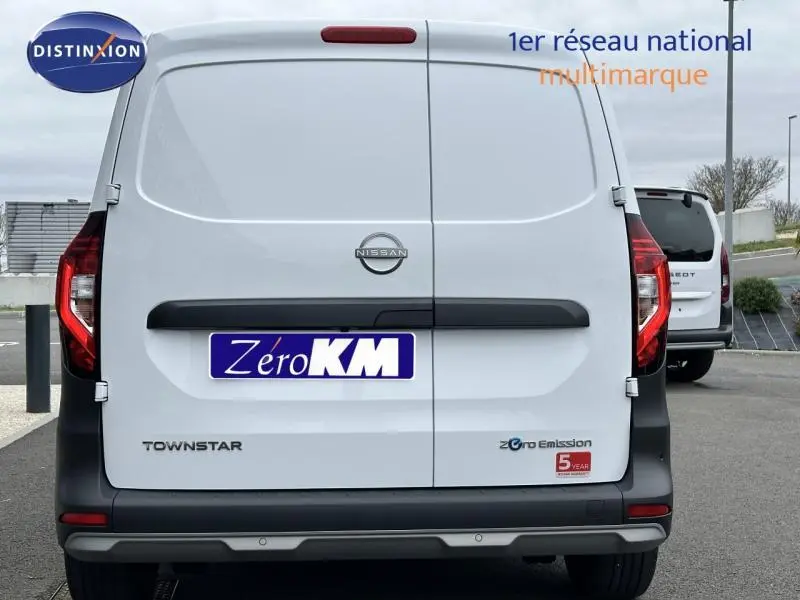 Vue arrière d'un utilitaire Nissan Townstar blanc minéral électrique avec portes battantes et logo Zero Emission visible.