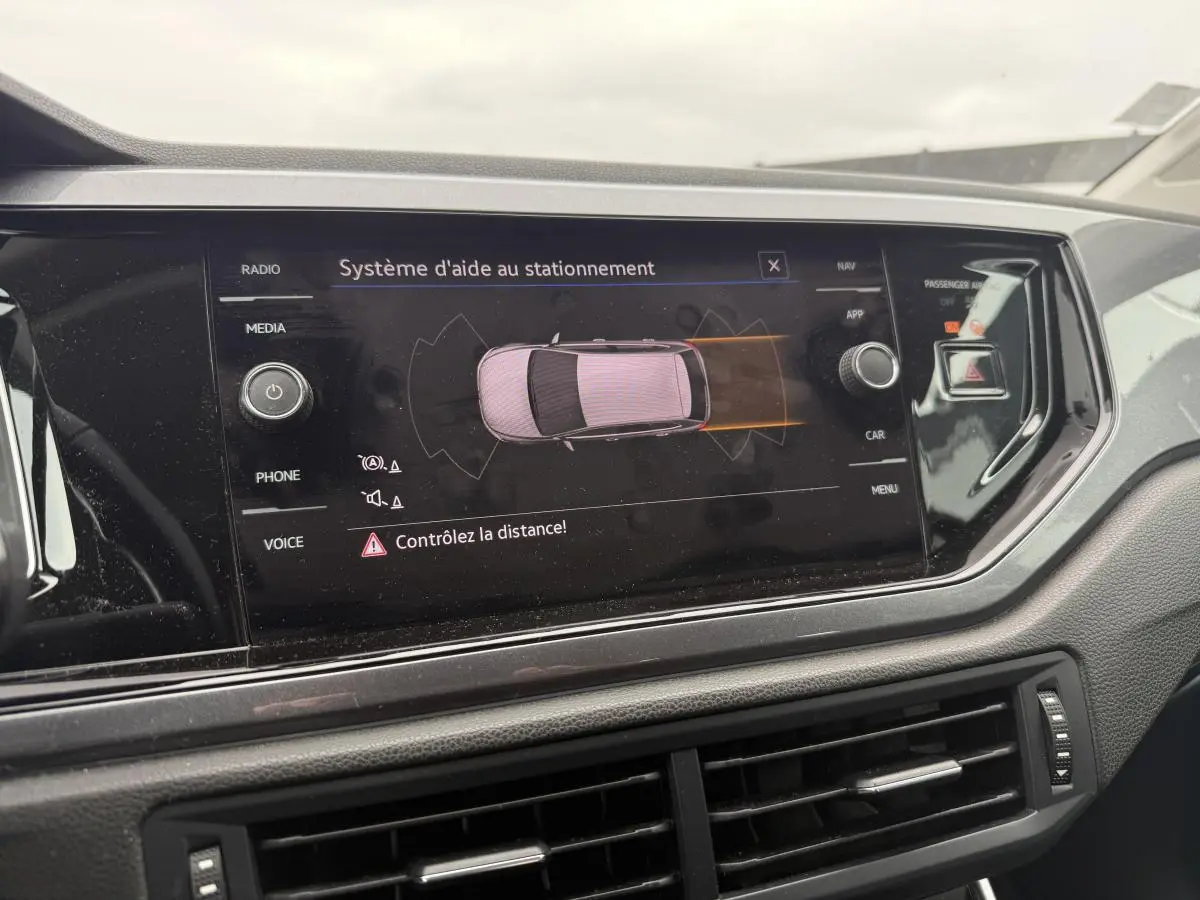 Écran tactile du système d'aide au stationnement dans le tableau de bord d'une Volkswagen Polo bleue 2021.