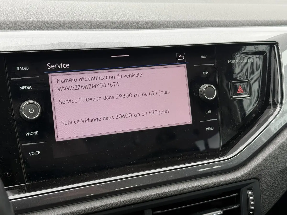 Écran tactile central affichant les informations de service dans l'habitacle d'une Volkswagen Polo 1.0 TSI bleu.