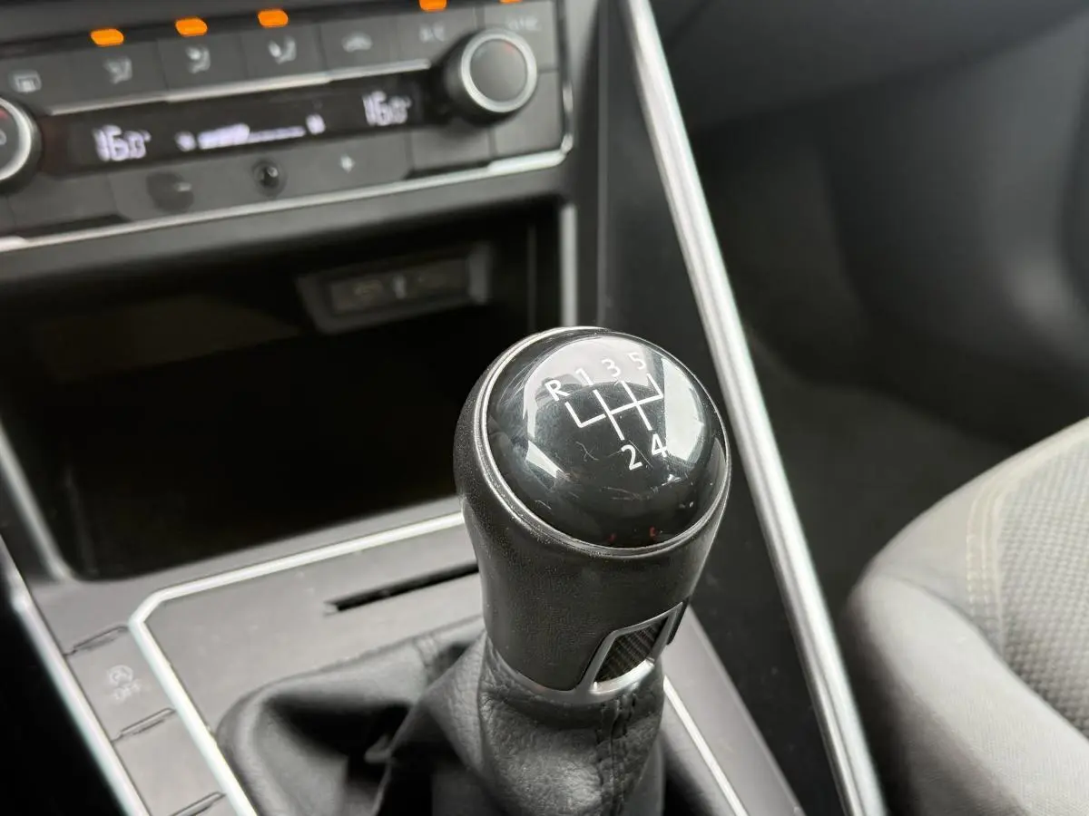 Le levier de vitesses manuel noir de la Volkswagen Polo 1.0 TSI R-Line 2021, avec console grise et siège tissu visible.