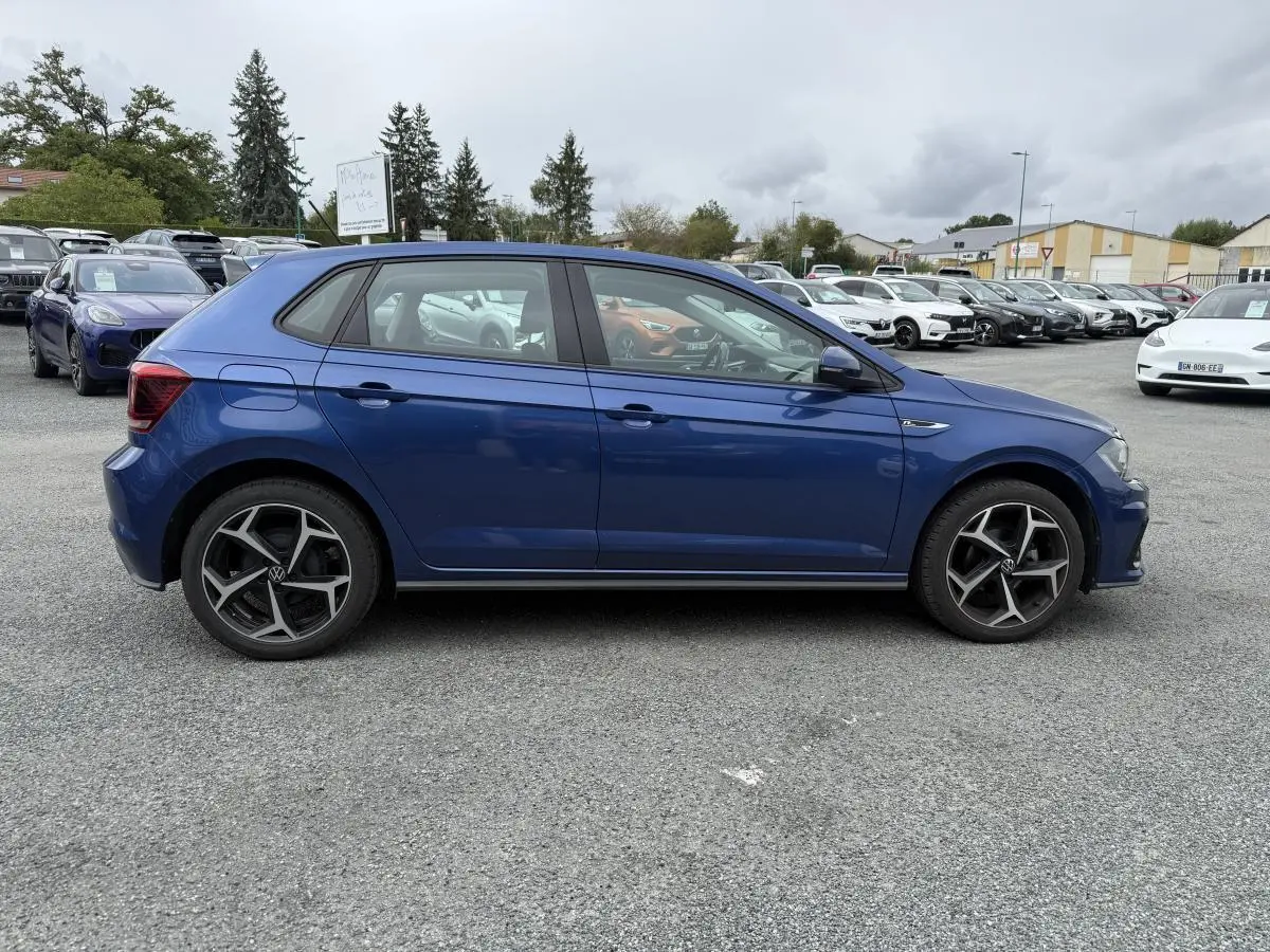 Profil côté gauche d'une Volkswagen Polo 1.0 TSI R-Line bleu métallisé avec jantes alliage 17 pouces sur parking.