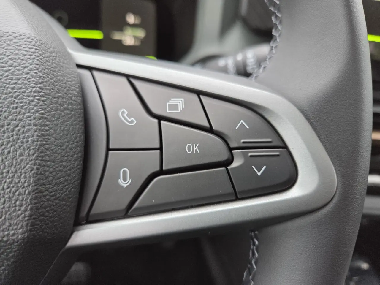 Gros plan sur les commandes au volant côté droit du Dacia Bigster 2025, finition Extreme, intérieur noir.