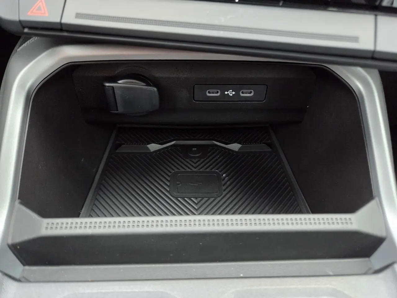 Gros plan sur la console centrale noire du Dacia Bigster 2025 avec deux ports USB-C et chargeur à induction intégré.