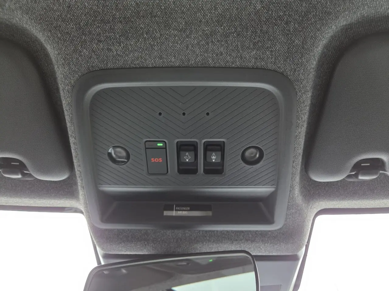 Vue intérieure du plafonnier du Dacia Bigster blanc glacier 2025 avec boutons SOS et commandes toit ouvrant.