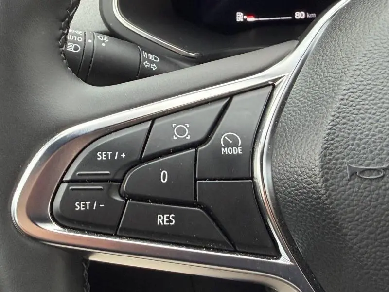 Gros plan sur les commandes au volant côté gauche du Renault Captur 2025, finition Techno, avec boutons de régulateur de vitesse.