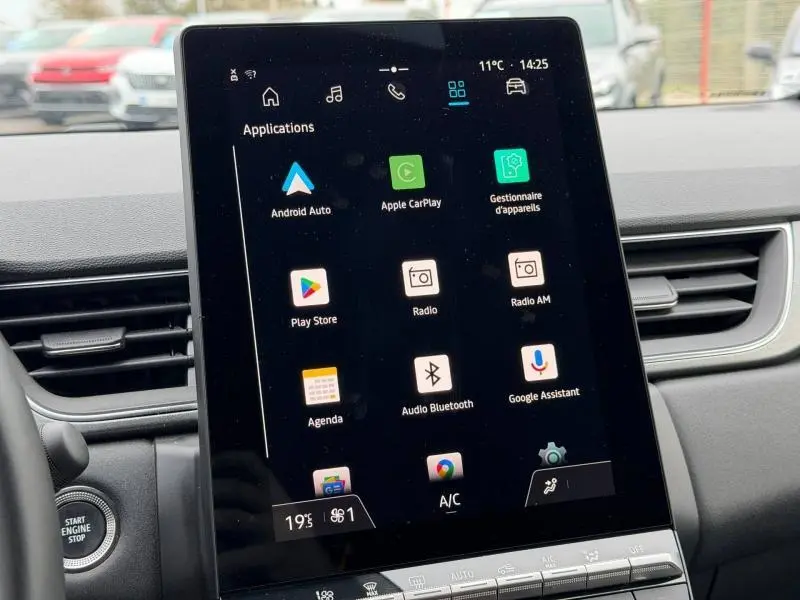 Écran tactile central du Renault Captur 2025 affichant les applications connectées, avec tableau de bord gris en arrière-plan.