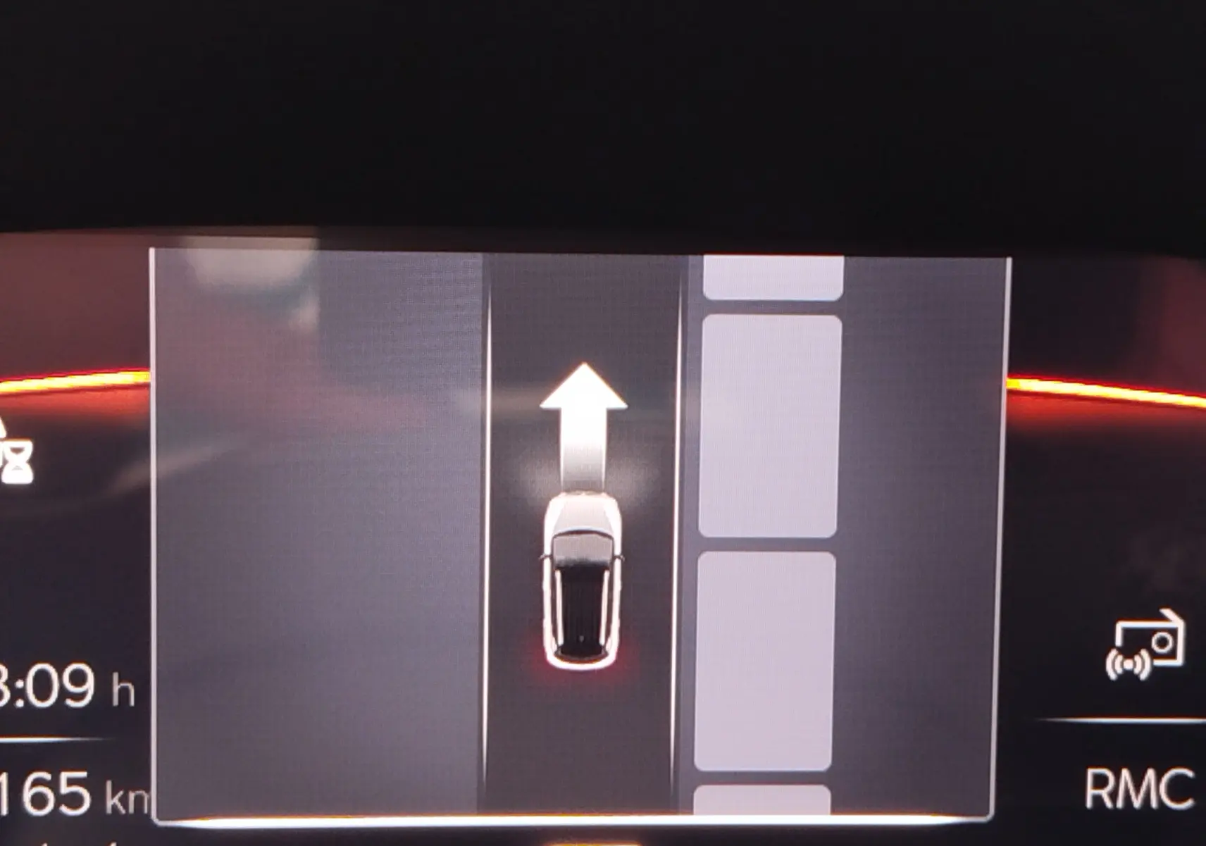 Affichage numérique du tableau de bord montrant la voiture blanche en vue de dessus avec une flèche indiquant la direction vers l'avant.