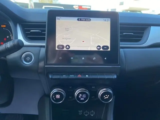 Tableau de bord du Renault Captur E-Tech gris Cassiopée, affichage central tactile avec navigation et commandes climatiques.