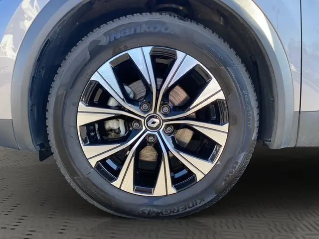 Gros plan sur la roue avant droite du Renault Captur gris Cassiopée, mettant en valeur la jante alliage noire et argentée.