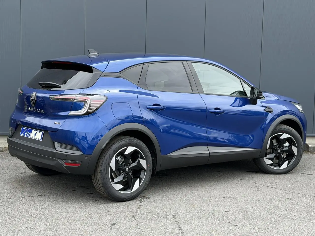 Vue 3/4 arrière droite du Renault Captur 2026 bleu Iron avec jantes aluminium 18 pouces Black Hole.