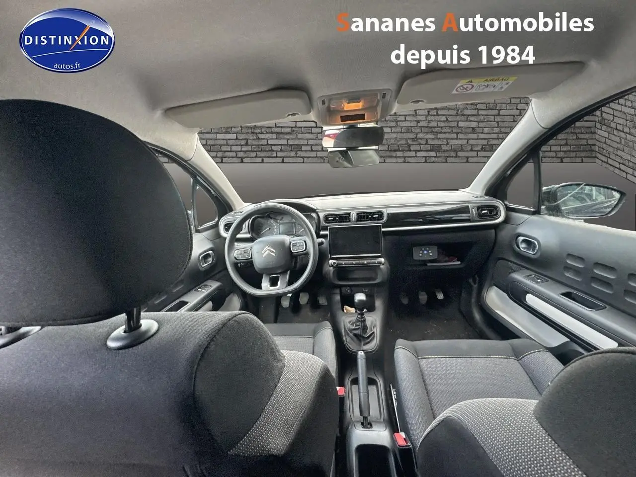 Vue intérieure avant du Citroën C3 noir 2023, montrant le tableau de bord moderne et volant multifonction.