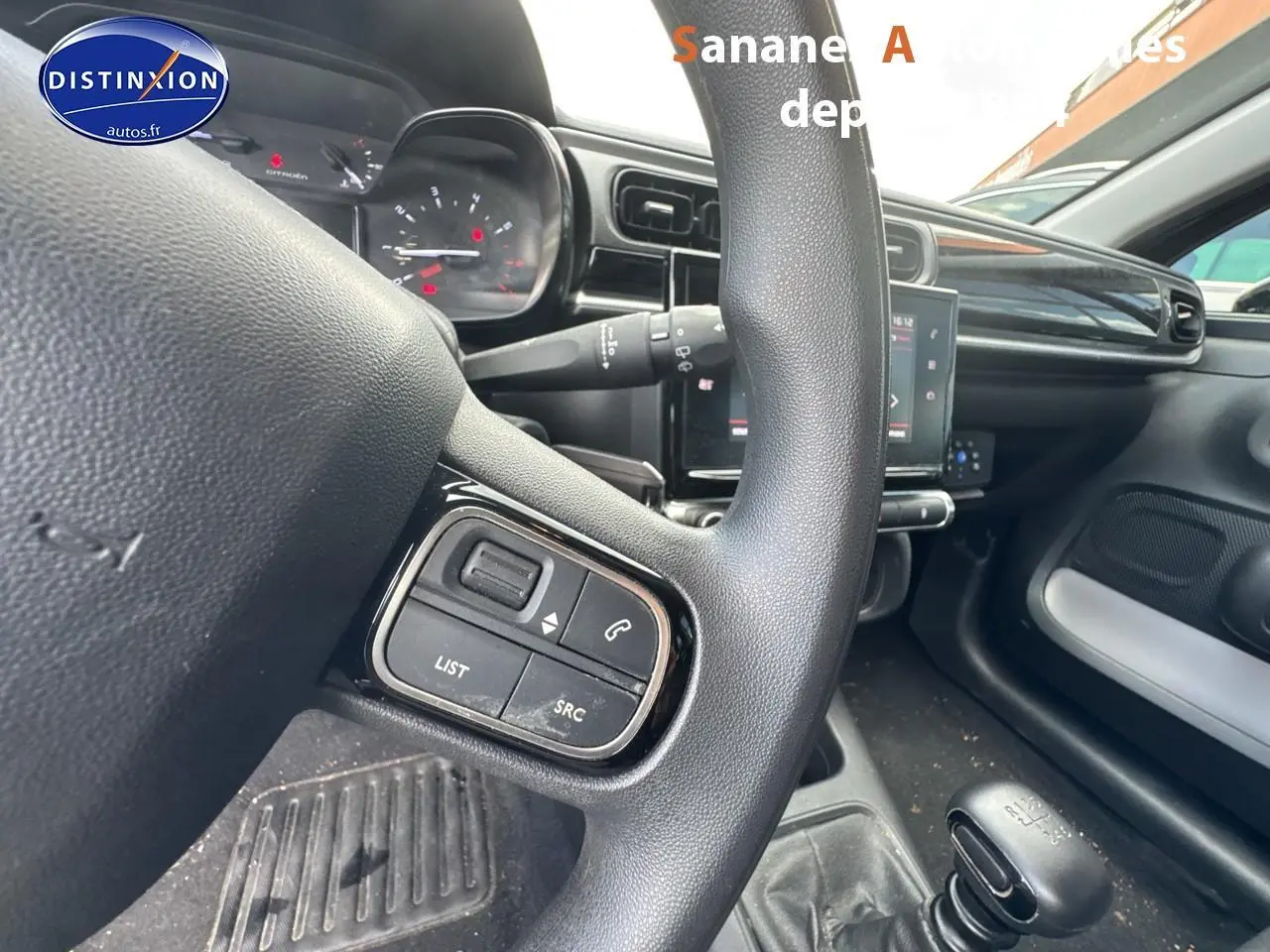 Gros plan sur le volant multifonction noir et la console centrale d'une Citroën C3 2023 diesel avec boîte manuelle.
